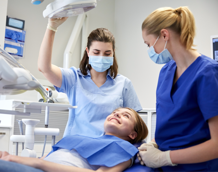 Little Girl in a Dentist Office with Two Dental Hygienist in Raleigh, NC Little Girl in a Dentist Office with Two Dental Hygienist in Raleigh, NC