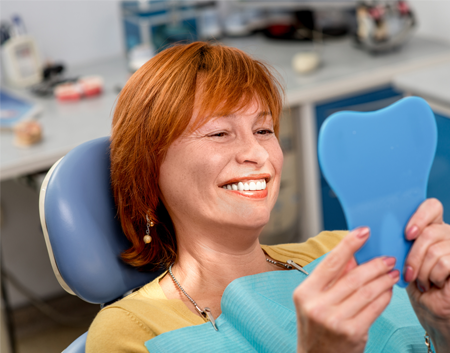 Happy Woman Looking at Her Clean Teeth in Raleigh, NC 
